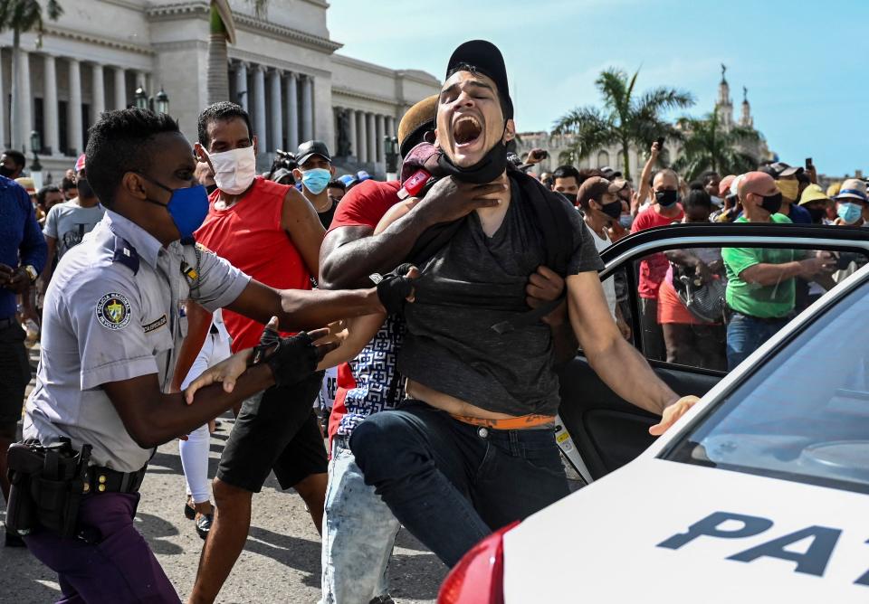 TOPSHOT - A man is arrested during a demonstration against the government of Cuban President Miguel Diaz-Canel in Havana, on July 11, 2021. - Thousands of Cubans took part in rare protests Sunday against the communist government, marching through a town chanting 