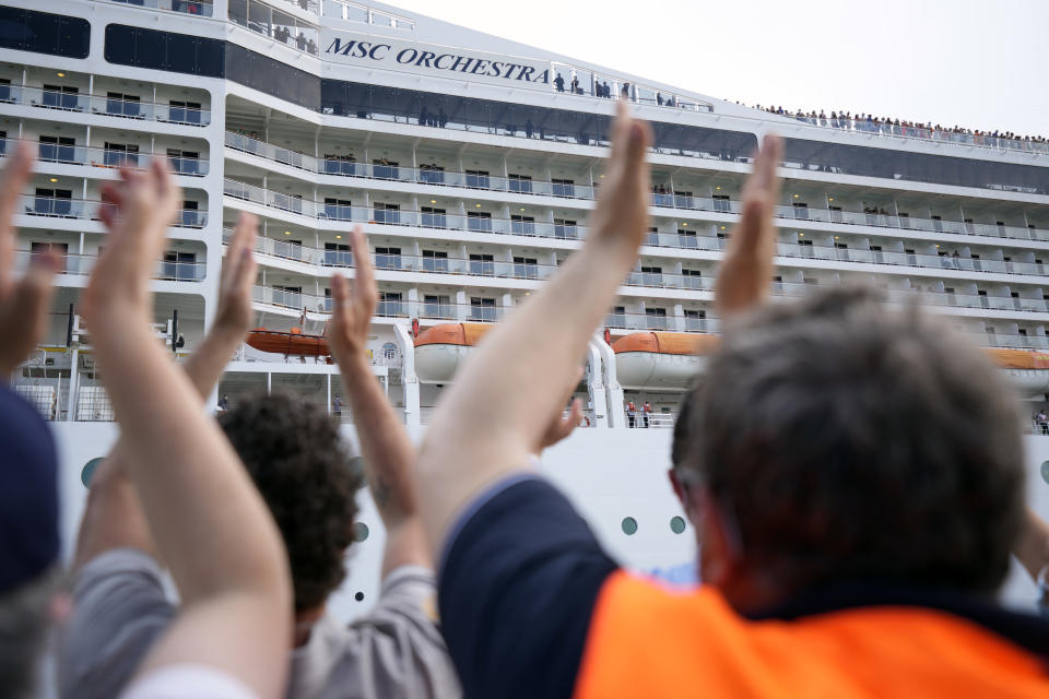 People applaud as the 92,409-ton, 16-deck MSC Orchestra cruise ship departs from Venice, Italy, Saturday, June 5, 2021. The first cruise ship leaving Venice since the pandemic is set to depart Saturday amid protests by activists demanding that the enormous ships be permanently rerouted out the fragile lagoon, especially Giudecca Canal through the city's historic center, due to environmental and safety risks. The cruiser passed two groups of protesters: pro-cruise advocates whose jobs depend on the industry as well as protesters belonging to a movement called "No Big Ships" who have been campaigning for years to get cruise ships out of the lagoon. (AP Photo/Antonio Calanni)