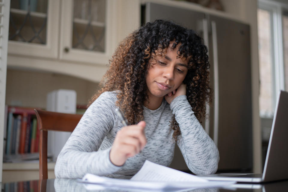 Woman doing paperwork in front of a computer