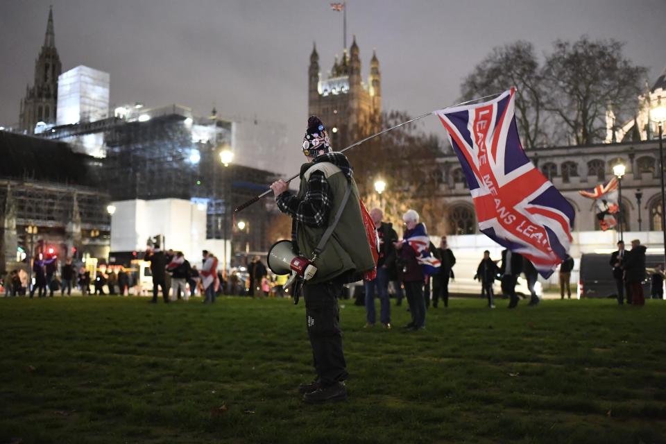 A Brexit supporter holds a British flag during a rally in London, Friday, Jan. 31, 2020. Britain officially leaves the European Union on Friday after a debilitating political period that has bitterly divided the nation since the 2016 Brexit referendum. (AP Photo/(AP Photo/Alberto Pezzali)