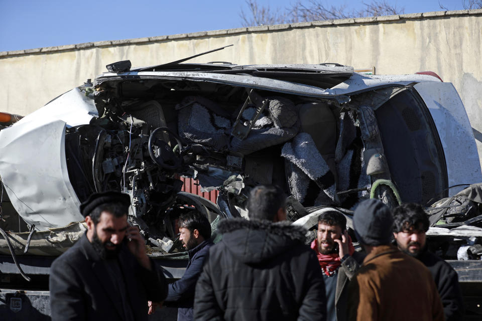 Afghan security personnel inspect the site of a roadside bomb attack in Kabul, Afghanistan, Tuesday, Dec. 22, 2020. A roadside bomb tore through a vehicle in the Afghan capital of Kabul Tuesday, killing multiple people, police said. (AP Photo/Rahmat Gul)