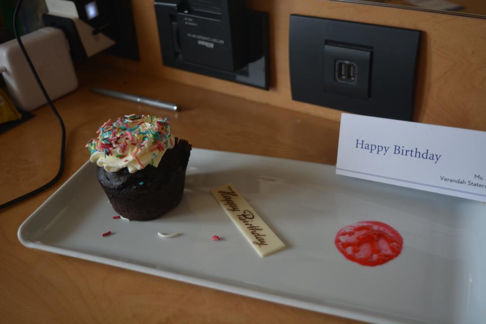 Cupcake and birthday card on a cruise ship nightstand