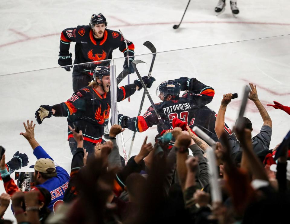 Coachella Valley Firebirds players celebrate the game winning goal by forward Andrew Poturalski (22) during overtime of game five of the Pacific Division finals at Acrisure Arena in Palm Desert, Calif., Friday, May 19, 2023. 