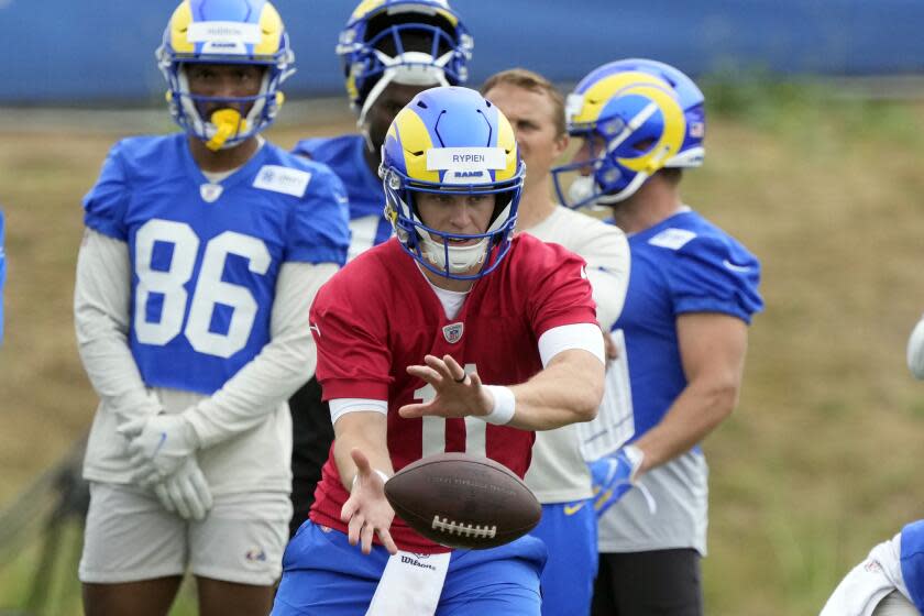 Rams quarterback Brett Rypien takes a snap during practice.