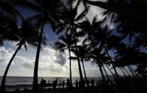 PALM COVE, AUSTRALIA - NOVEMBER 14: Spectators line the beach to view the total solar eclipse on November 14, 2012 in Palm Cove, Australia. Thousands of eclipse-watchers have gathered in part of North Queensland to enjoy the solar eclipse, the first in Australia in a decade. (Photo by Ian Hitchcock/Getty Images)