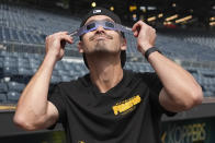 Pittsburgh Pirates' Bryan Reynolds views the solar eclipse before a baseball game against the Detroit Tigers in Pittsburgh, Monday, April 8, 2024. (AP Photo/Gene J. Puskar)