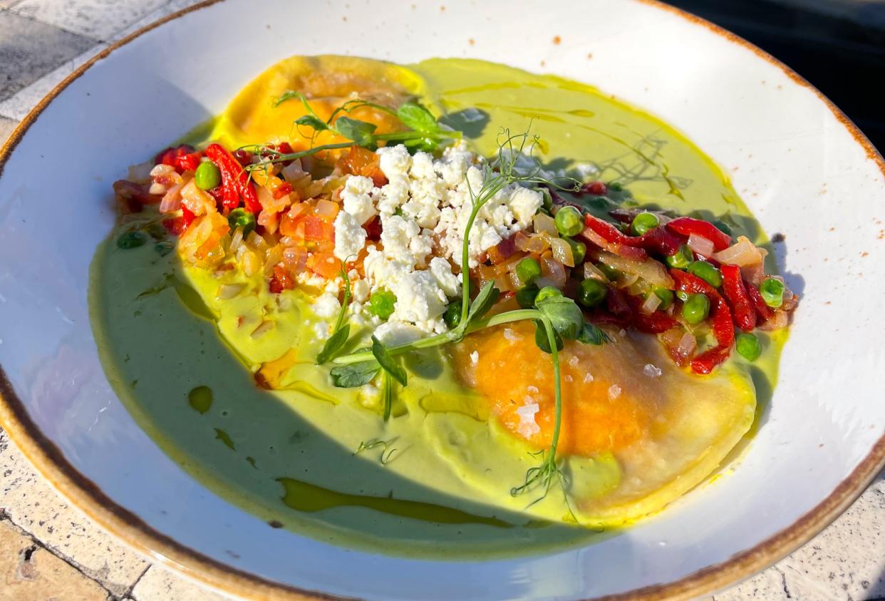 The Lazy Goat's Ravioli do Pepe Piquillo dish, featuring ricotta and feta cheese, bacon, piquillo peppers, Vidalia onion, English peas, and a creamy green harissa.