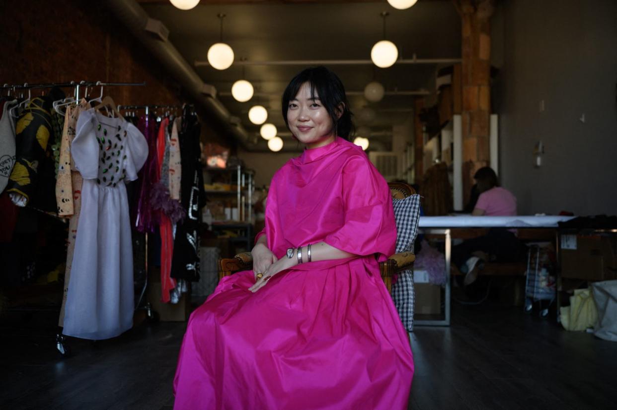 dauphinette designer olivia cheng poses in an oversize pink dress