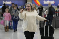 Marissa Colleluori talks to her granddaughter through FaceTime at the Nashville International Airport, Tuesday, Nov. 21, 2023, in Nashville, Tenn. before boarding her flight to Buffalo for the Thanksgiving holiday. Despite inflation and memories of past holiday travel meltdowns, millions of people are expected to hit airports and highways in record numbers over holiday. (AP Photo/George Walker IV)