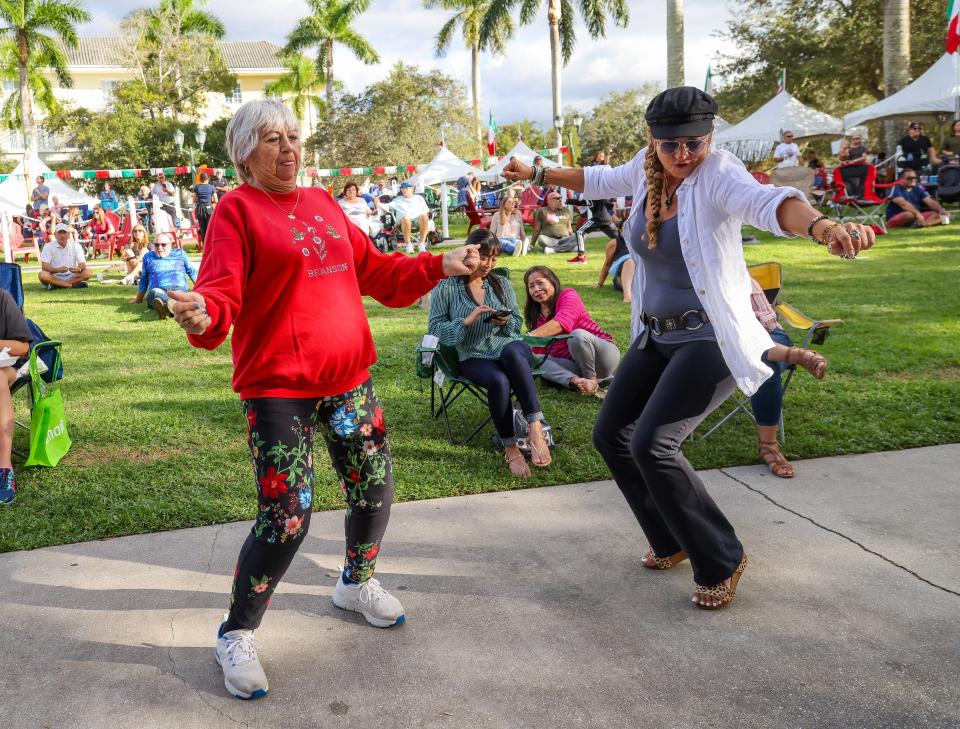 Frances Valek, left, and Linda Mondazze dance during the 2021 Feast of Little Italy at Abacoa Town Center in Jupiter. This year, the three-day fest celebrates its 21st anniversary from Nov. 4 to 6.