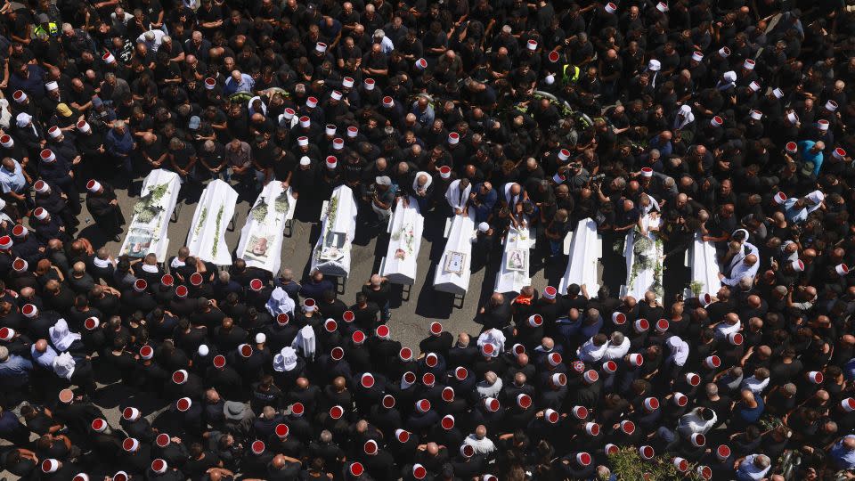 Druze elders and mourners surround the coffins of 10 of the children killed in Saturday's strike. - Menahem Kahana/AFP/Getty Images