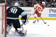 Calgary Flames center Dillon Dube (29) shoots on Seattle Kraken goaltender Martin Jones (30) during the second period of an NHL hockey game Friday, Jan. 27, 2023, in Seattle. (AP Photo/John Froschauer)