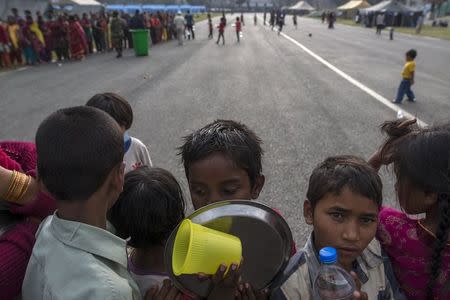 Victims of the April 25 earthquake line up during a food and water distribution at a camp for displaced people, in Kathmandu, Nepal, May 7, 2015. REUTERS/Athit Perawongmetha