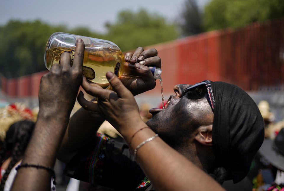 A man dressed as a revolutionary Zacapoaxtla Indigenous soldier drinks tequila during the re-enactment of The Battle of Puebla as part of Cinco de Mayo celebrations in the Peñon de los Baños neighborhood of Mexico City, Thursday, May 5, 2022. Cinco de Mayo commemorates the victory of an ill-equipped Mexican army over French troops in Puebla on May 5, 1862. (AP Photo/Eduardo Verdugo)