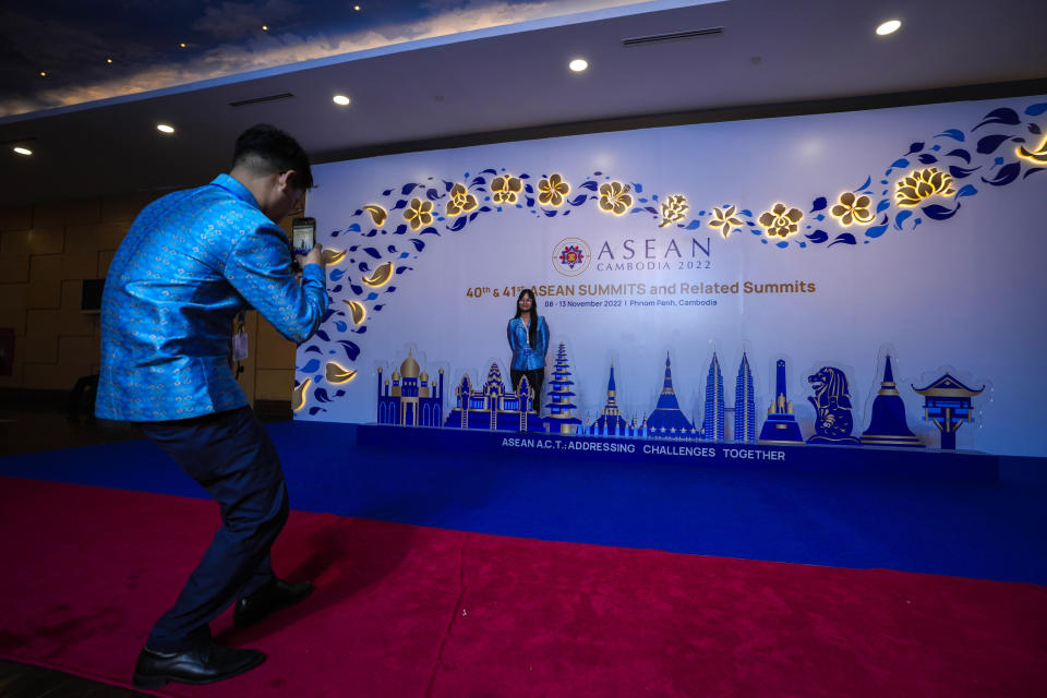 A volunteer takes a photo of another at the ASEAN summit venue, in Phnom Penh, Cambodia, Wednesday, Nov. 9, 2022. Southeast Asian leaders convene in the Cambodian capital Thursday, faced with the challenge of trying to curtail escalating violence in Myanmar while the country's military-led government shows no signs of complying with the group's peace plan. (AP Photo/Anupam Nath)
