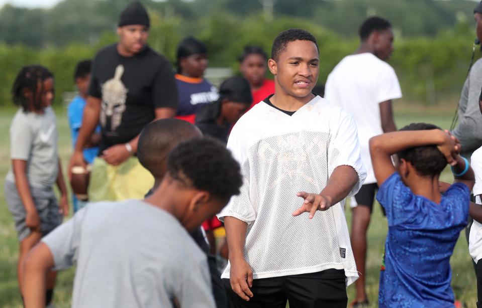 Elijah Gervins, a North High football player, works with campers during the first annual Sonil Haslam Community Youth Football Camp at North High School on Wednesday.