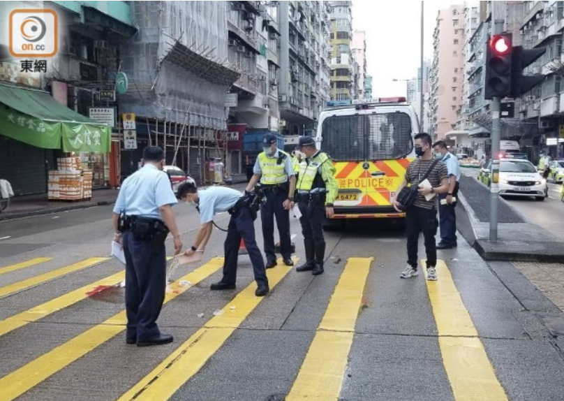 警員用水清洗血漬。(胡德威攝)
