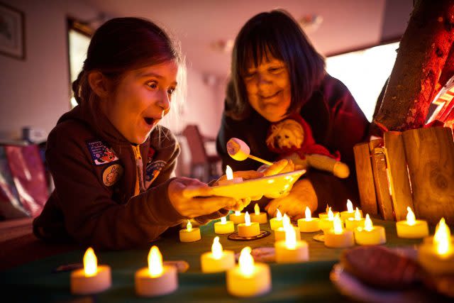 Frankie Fernandez, eight, from 2nd Northenden (St Wilfrid's) Brownies, with Veronica Armstrong, 67, around a camp fire