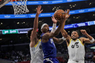 Los Angeles Clippers guard-forward Terrance Mann, center, scores against Utah Jazz guard Keyonte George, left, and guard Talen Horton-Tucker (5) during the first half of an NBA basketball game Friday, April 5, 2024, in Los Angeles. (AP Photo/Etienne Laurent)