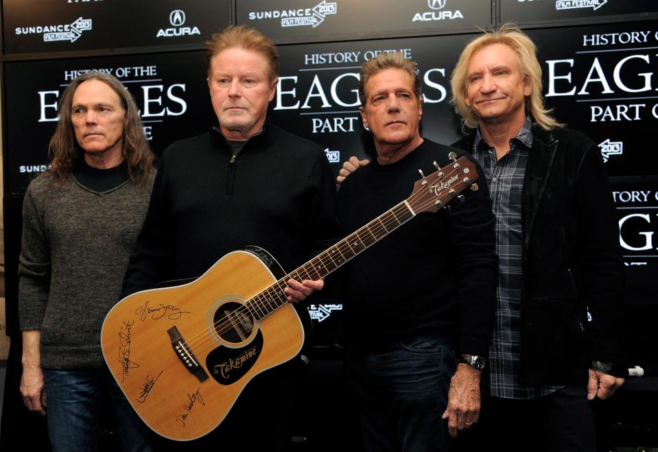 FILE - Members of The Eagles, from left, Timothy B. Schmit, Don Henley, Glenn Frey and Joe Walsh pose with an autographed guitar after a news conference at the Sundance Film Festival, in Park City, Utah, Jan. 19, 2013. Three people were charged Tuesday, July 12, 2022, in an alleged conspiracy involving the handwritten lyrics to the classic rock juggernaut "Hotel California." (Photo by Chris Pizzello/Invision/AP, File) ORG XMIT: NYRD204