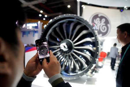 FILE PHOTO: A man takes a picture of a General Electric (GE) engine during the China International Import Expo (CIIE), at the National Exhibition and Convention Center in Shanghai, China November 6, 2018. REUTERS/Aly Song