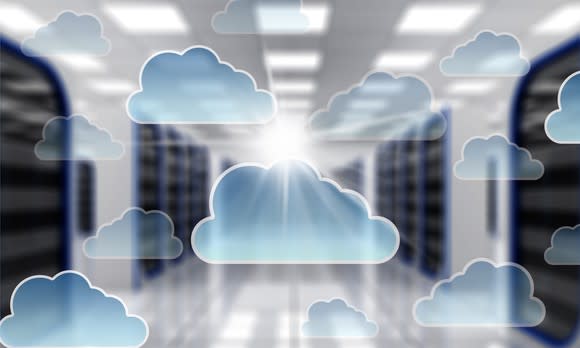 Cloud computing icons over a blurred background of servers.
