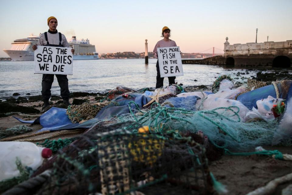 Ocean Rebellion activists hold banners reading “As the sea dies we die” and “No more fish in the sea” as they stage a protest in Terreiro do Paco, Lisbon on June 27, 2022, before the UN Ocean Conference (AFP via Getty Images)