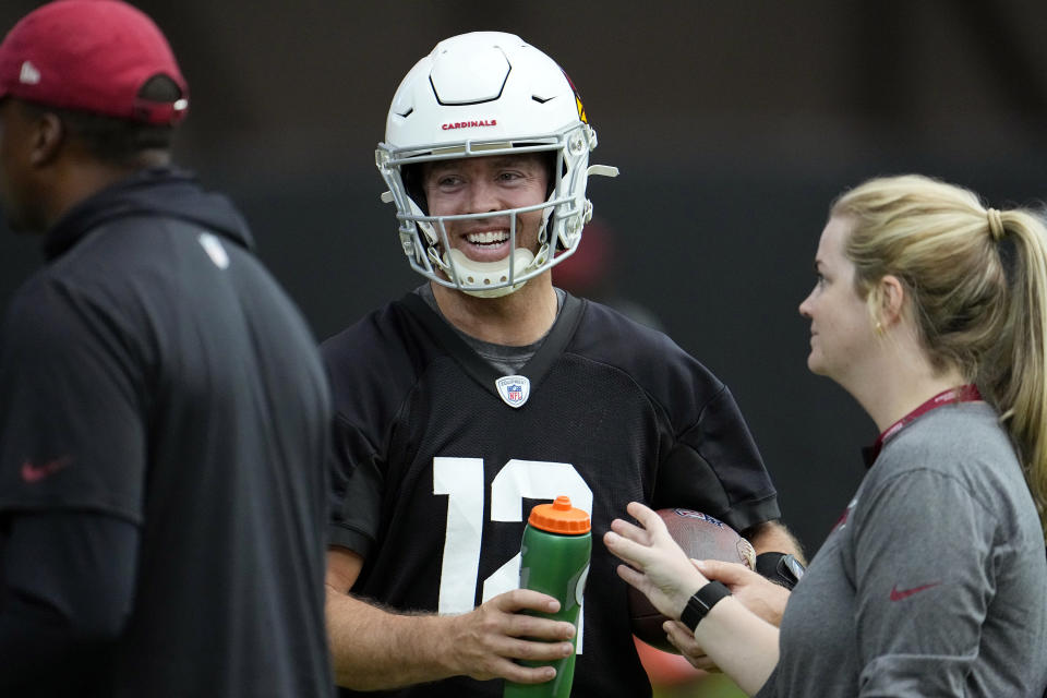 Arizona Cardinals quarterback Colt McCoy, center, smiles as he takes a break between drills during NFL football training camp practice at State Farm Stadium, Monday, Aug. 7, 2023, in Glendale, Ariz. (AP Photo/Ross D. Franklin)