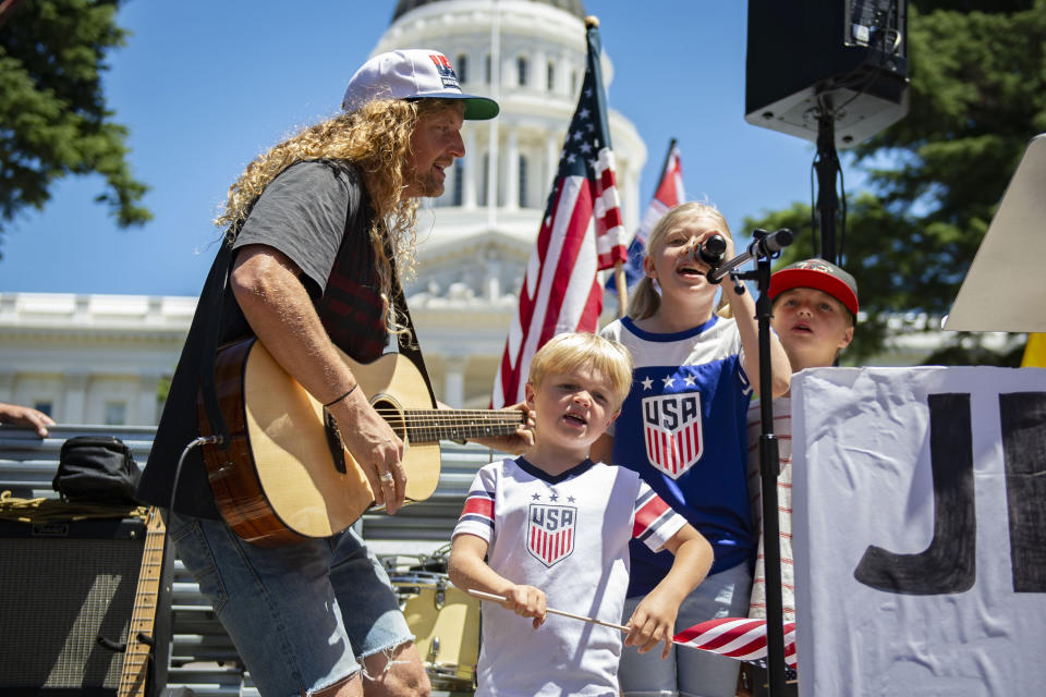 Sean Feucht sings on stage with his family, Ezra, 5, Keturah, 9, and Malachi, 7, in front of the west steps of the state Capitol as protesters gathered at Liberty Fest to protest Gov. Gavin Newsom's stay-at-home order in Sacramento, Calif., Saturday, May 23, 2020. Hundreds of protesters rallied outside the Capitol on Saturday to protest against California's stay-at-home orders even as residents entered the Memorial Day weekend with newly expanded options for going to the beach, barbecuing and shopping. (Jason Pierce/The Sacramento Bee via AP)