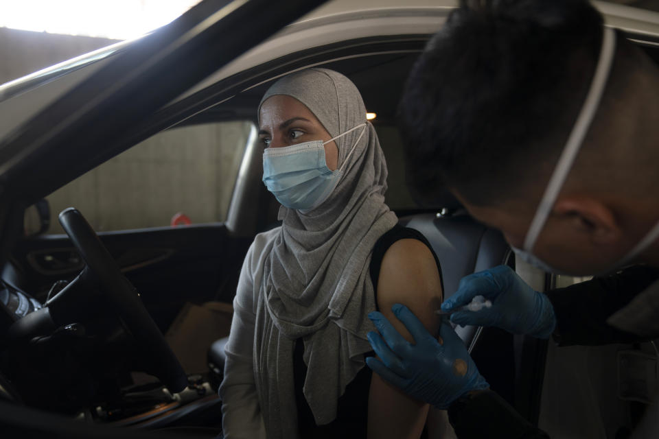 FILE - In this March 5, 2021, file photo, Dian Rana receives Pfizer's COVID-19 vaccine at a vaccination site in Long Beach, Calif. U.S. deaths from COVID-19 are falling again as the nation recovers from the devastating winter surge. Most forecasts predict coronavirus deaths will fall further in coming weeks, as more people are vaccinated. (AP Photo/Jae C. Hong, File)