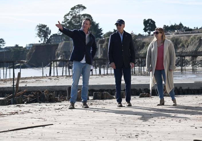 President Joe Biden, California Governor Gavin Newsom, and a small business owner survey damage caused by recent heavy storms in Capitola, California (AFP via Getty Images)