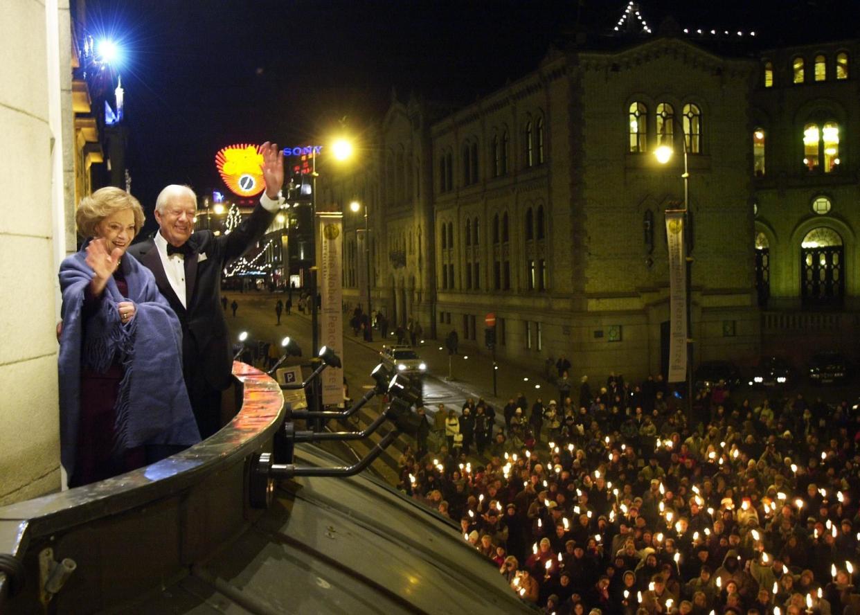 Nobel Peace Prize winner, former President Jimmy Carter; and his wife Rosalynn, greet wellwishers during a torchlight procession on Dec. 10, 2002, from the balcony of Grand Hotel, prior to the Norwegian Nobel Committee's banquet, in Oslo, Norway.