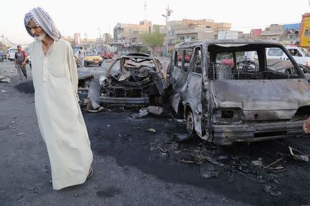 A man walks past the site of a car bomb attack in Baghdad's Sadr City, in this August 7, 2014 file photo. REUTERS/Wissm al-Okili/Files