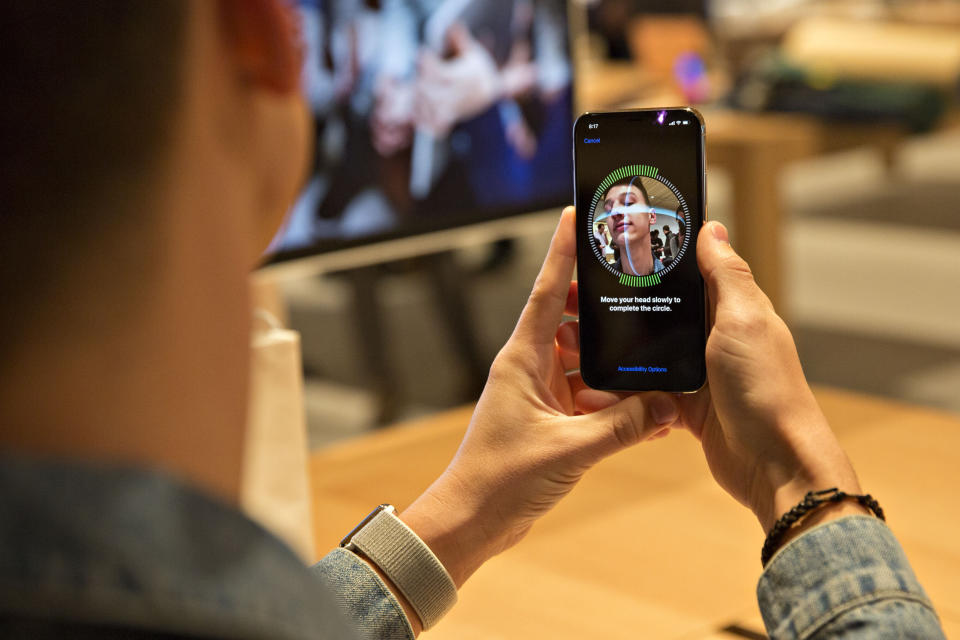 A customer sets up facial recognition on an Apple Inc. iPhone X smartphone during the sales launch at a store in Chicago, Illinois, U.S., on Friday, Nov. 3, 2017. The $1,000 price tag on Apple Inc.'s new iPhone X didn't deter throngs of enthusiasts around the world who waited -- sometimes overnight -- in long lines with no guarantee they would walk out of the store with one of the coveted devices. Photographer: Daniel Acker/Bloomberg via Getty Images