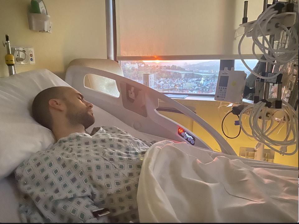 Anthony Di Laura, who has a rare form of cancer, lies in a hospital bed after having undergone one of three surgeries.