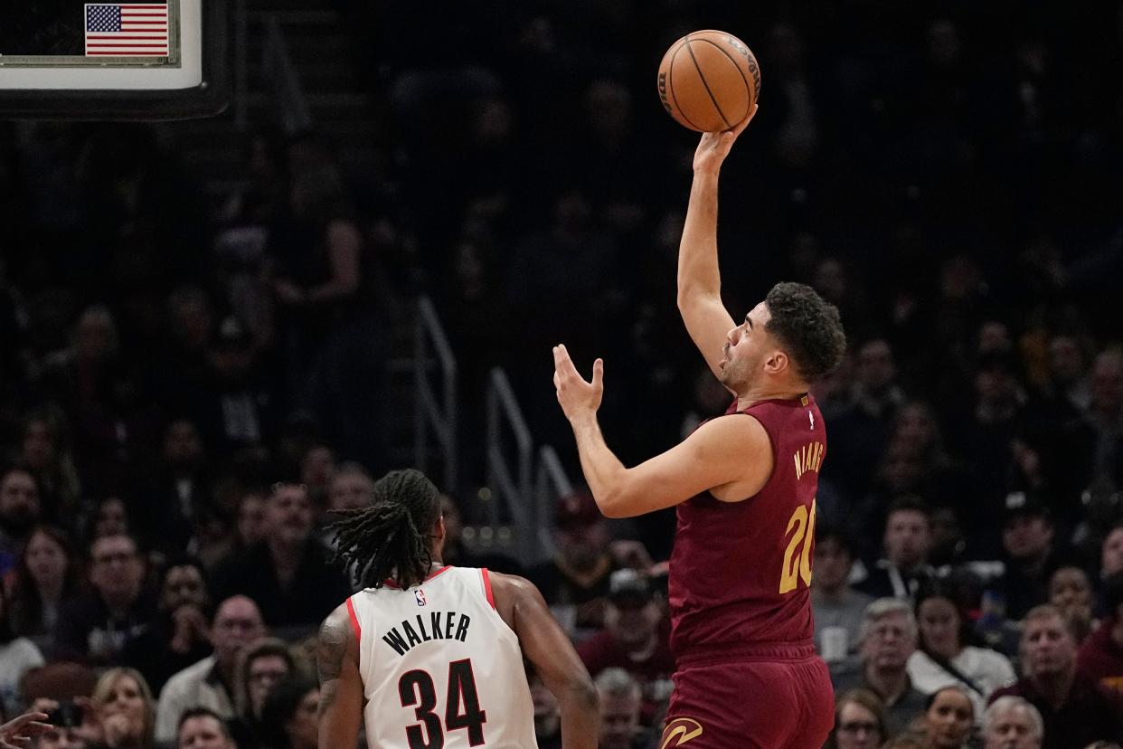 Cleveland Cavaliers forward Georges Niang (20) shoots next to Portland Trail Blazers forward Jabari Walker (34) during the first half of an NBA basketball game Thursday, Nov. 30, 2023, in Cleveland. (AP Photo/Sue Ogrocki)