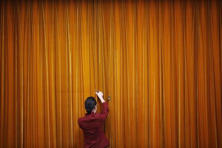 An attendant puts clamps on a curtain inside the Great Hall of the People during the closing ceremony of the Chinese People's Political Consultative Conference (CPPCC) in Beijing, in this March 12, 2014 file photo. REUTERS/Kim Kyung-Hoon/Files