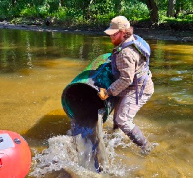 Volunteer Matthew Edmonds helps remove trash and debris from Lansing's waterways.