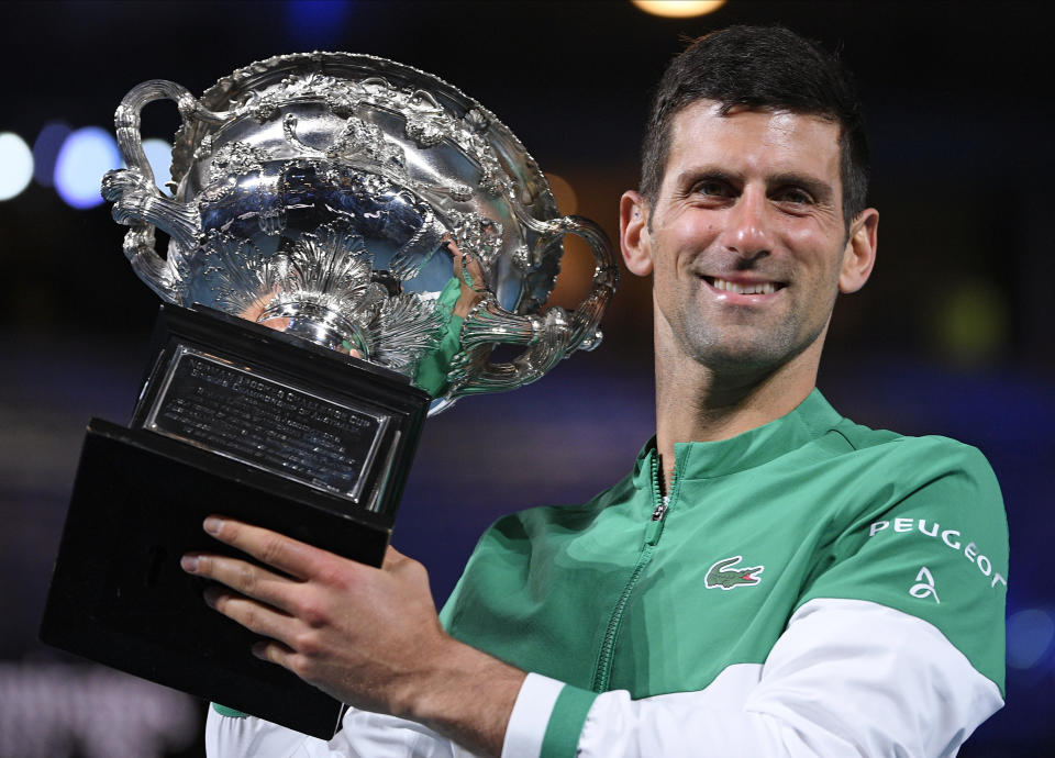 Serbia's Novak Djokovic holds the Norman Brookes Challenge Cup after defeating Russia's Daniil Medvedev in the men's singles final at the Australian Open tennis championship in Melbourne, Australia, Sunday, Feb. 21, 2021.(AP Photo/Andy Brownbill)