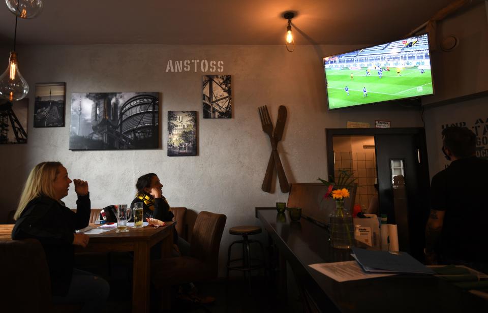 Supporters of Borussia Dortmund watch the German first division Bundesliga football match BVB Borussia Dortmund v Schalke 04 at at the bar  Schmackes on May 16, 2020 in Dortmund, western Germany as the season resumed following a two-month absence due to the novel coronavirus COVID-19 pandemic. (Photo by INA FASSBENDER / AFP) (Photo by INA FASSBENDER/AFP via Getty Images)