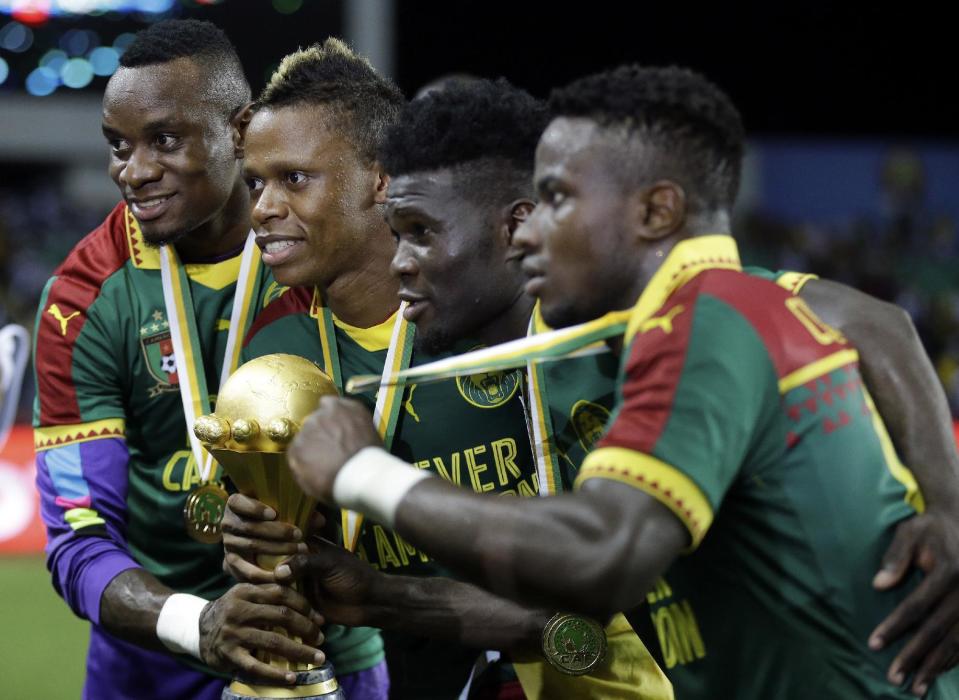 Cameroon players pose with the trophy after winning the African Cup of Nations final soccer match between Egypt and Cameroon at the Stade de l'Amitie, in Libreville, Gabon, Sunday, Feb. 5, 2017. Cameroon won 2-1. (AP Photo/Sunday Alamba)