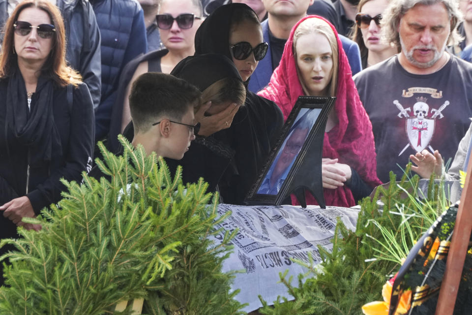 People react by the coffin of the Wagner Group's logistics chief Valery Chekalov, killed in the plane crash, during a funeral at the Severnoye cemetery in St. Petersburg, Russia, Tuesday, Aug. 29, 2023. The plane crash came exactly two months after Wagner Group's chief Yevgeny Prigozhin launched a rebellion against the Russian military leadership, leading his mercenaries to take over the military headquarters in the southern city of Rostov-on-Don and then launching a march on Moscow. (AP Photo/Dmitri Lovetsky)