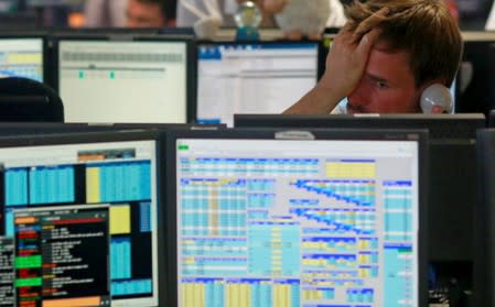 Traders from BGC, a global brokerage company in London's Canary Wharf financial centre react as European stock markets open