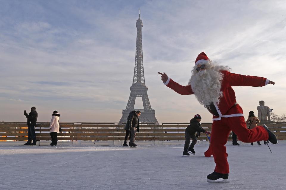 A man dressed as Santa Claus skates on an ice rink across from the Eiffel Tower as part of the Christmas holiday season preparations, in Paris December 12, 2013. REUTERS/Jacky Naegelen (FRANCE - Tags: SOCIETY TRAVEL TPX IMAGES OF THE DAY)