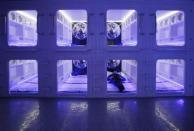 Eric Wong, managing director of a capsule bed manufacturer, poses in a modified capsule bed inside a showroom in Hong Kong January 7, 2012. The beds, which are modified for the Hong Kong market, have adjustable ceilings, a larger air conditioner and a TV. They are aimed at university students and budget mainland Chinese travelers visiting the territory and will cost $450 a month or $30 a night, according to the manufacturer.