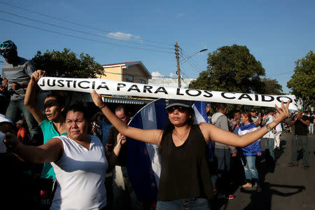 Demonstrators show a sign reading "Justice for the fallen", referring to demonstrators killed in protests against a reform to pension plans, during a protest against police violence and the government of Nicaraguan President Daniel Ortega in Managua, Nicaragua April 23, 2018. REUTERS/Oswaldo Rivas