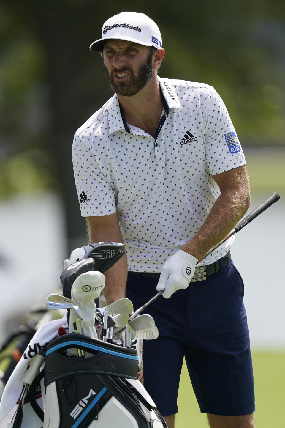 Dustin Johnson selects a club from his bag on the practice range during practice for the Tour Championship golf tournament at East Lake Golf Club Thursday, Sept. 3, 2020, in Atlanta. (AP Photo/John Bazemore)