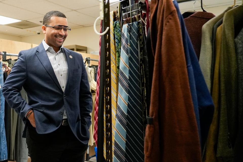 Ohio Rep. Sedrick Denson admires the collection of ties available to community center goers on Friday, July 21, 2023, at Valley Interfaith Community Resource Center in Village of Lockland in Cincinnati.