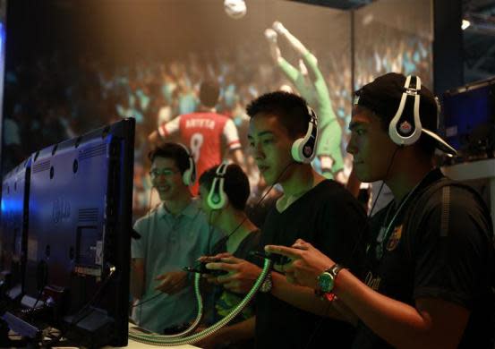 Visitors play FIFA13 during the Gamescom 2012 fair in Cologne August 16, 2012.