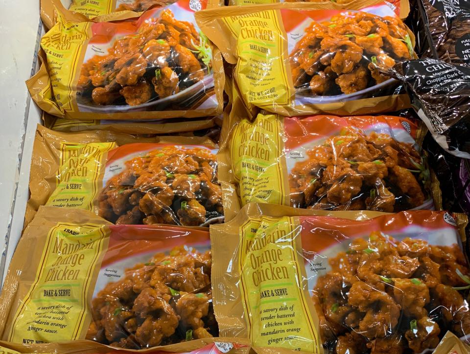 yellow and orange bags of orange chicken in trader joe's freezer section